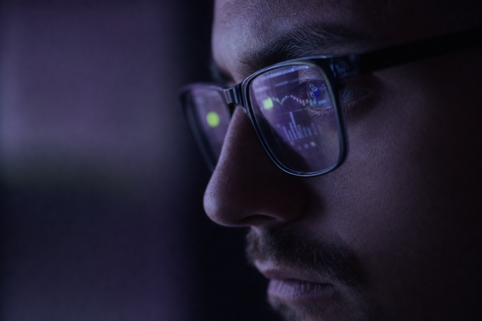 Analytics dashboard reflected in reading glasses, editorial portrait